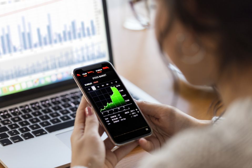 Young finance expert analyzing financial charts on a smartphone