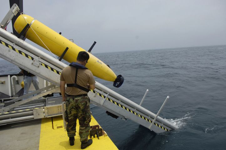 An employee of the U.S. Navy's main airbrush with naval mines and anti-submarine command in Corpus Christi, Texas, oversees the deployment of an autonomous submarine (AUV). (US Navy)