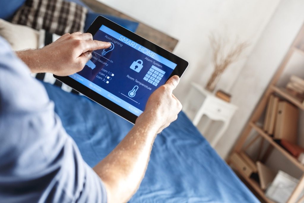 a man who deals with an intelligent home security system on a tablet